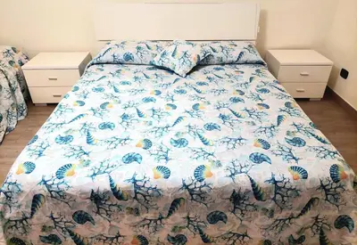 a bed with a floral comforter in a bedroom at La Casa dei Melograni in Rome