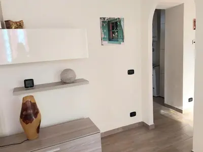 a room with a white wall with a vase on a bench at La Casa dei Melograni in Rome