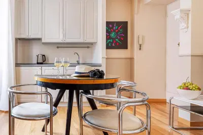 a kitchen with a table with chairs and wine glasses at Navona Boutique House in Rome