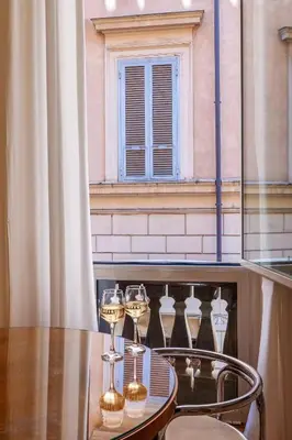 a table with wine glasses on a table with a window at Navona Boutique House in Rome