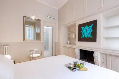 a white kitchen with a table and a fireplace at Navona Boutique House in Rome