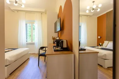 a hotel room with two beds and a kitchen with a microwave at Porta Pia Stay GuestHouse in Rome