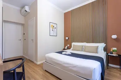 a bedroom with a large bed and a chair at Porta Pia Stay GuestHouse in Rome