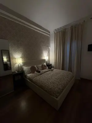 a bedroom with a bed with two tables and two lamps at Suncity Sweet Home in Rome