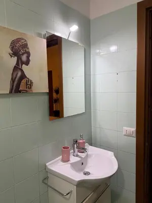 a white bathroom with a sink and a mirror at Suncity Sweet Home in Rome