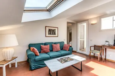 a living room with a green couch and a table at Frangipane Colosseum Apartments in Rome