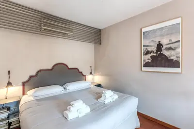 a bedroom with a large white bed with two towels at Frangipane Colosseum Apartments in Rome