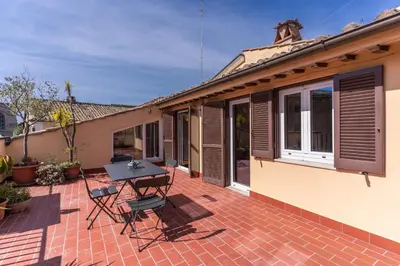 a patio with a table and chairs on a house at Frangipane Colosseum Apartments in Rome