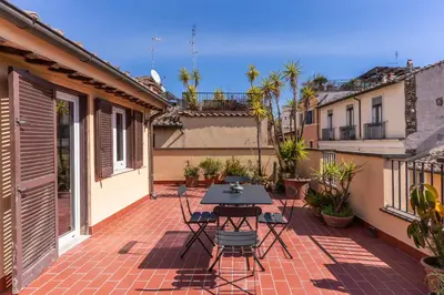 a patio with a table and chairs on a brick floor at Frangipane Colosseum Apartments in Rome