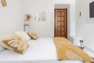 a white bedroom with a bed with two pillows at Vatican Area Stylish 2BR Fast WiFi & AC in Rome