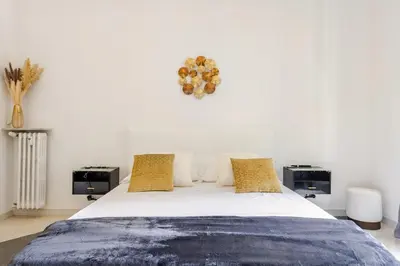a bedroom with a large white bed with yellow pillows at Vatican Area Stylish 2BR Fast WiFi & AC in Rome