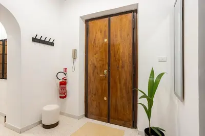 a wooden door in a room with a plant at Vatican Area Stylish 2BR Fast WiFi & AC in Rome
