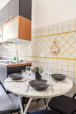a kitchen with a table with plates on it at Vatican Area Stylish 2BR Fast WiFi & AC in Rome