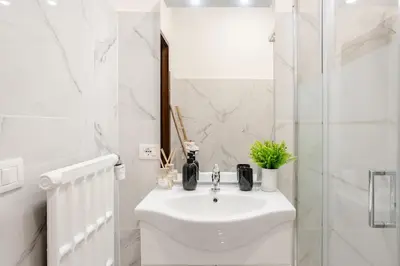 a white bathroom with a sink and a shower at Vatican Area Stylish 2BR Fast WiFi & AC in Rome