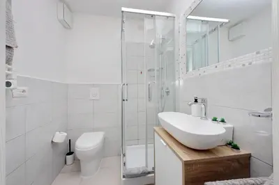 a white bathroom with a sink and a shower at Castro Pretorio Sweet Home in Rome
