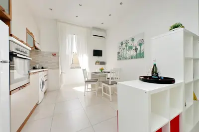 a kitchen with white appliances and a dining room at Castro Pretorio Sweet Home in Rome