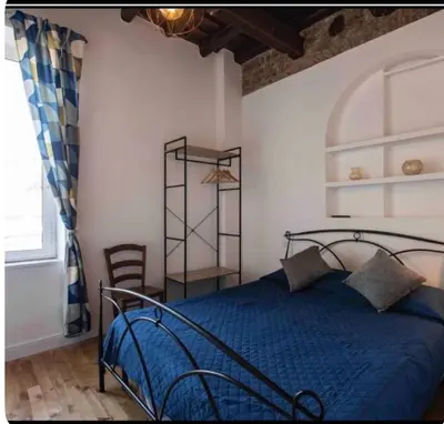 a bedroom with a blue bed and a window at Home trastevere in Rome