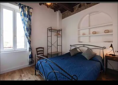 a bedroom with a blue bed and a window at Home trastevere in Rome