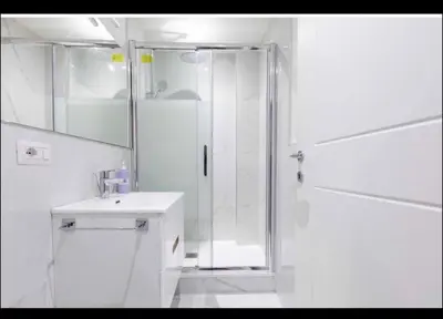 a white bathroom with a shower and a sink at Home trastevere in Rome