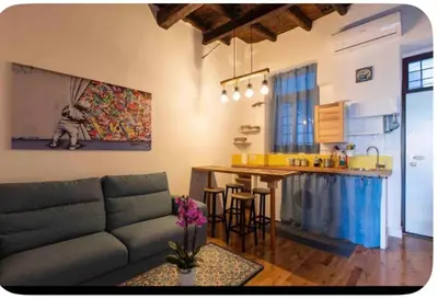 a living room with a couch and a kitchen at Home trastevere in Rome