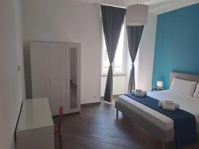 a bedroom with a bed and a table and a window at At Home Gaeta Guest House in Rome