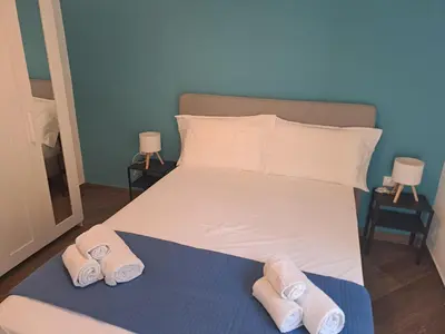 a bedroom with a bed with slippers on it at At Home Gaeta Guest House in Rome