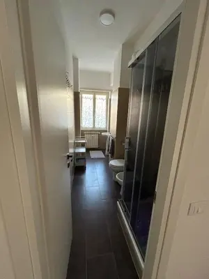 a bathroom with a toilet and a glass door at Casa Susanna in Rome
