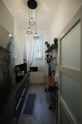 a kitchen with black counters and a window and a table at Graziosa camera in posizione strategia con bagno privato esterno in Rome