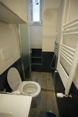 a small bathroom with a toilet and a window at Graziosa camera in posizione strategia con bagno privato esterno in Rome