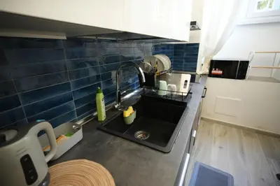 a small kitchen with a sink and blue tiles at Graziosa camera in posizione strategia con bagno privato esterno in Rome