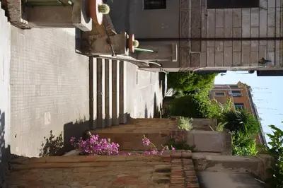 an alley with stairs and flowers on a building at Graziosa camera in posizione strategia con bagno privato esterno in Rome