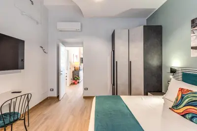a bedroom with a large bed and a tv at Trilocale indipendente vicino Metro per Colosseo - Domus in Rome in Rome