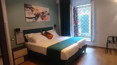 a bedroom with a bed in a room with a window at Trilocale indipendente vicino Metro per Colosseo - Domus in Rome in Rome