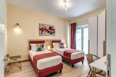 a hotel room with two beds and a desk at Trilocale indipendente vicino Metro per Colosseo - Domus in Rome in Rome