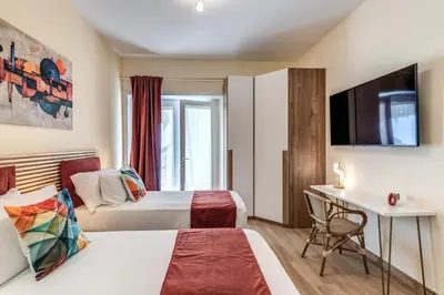 a hotel room with two beds and a desk at Trilocale indipendente vicino Metro per Colosseo - Domus in Rome in Rome