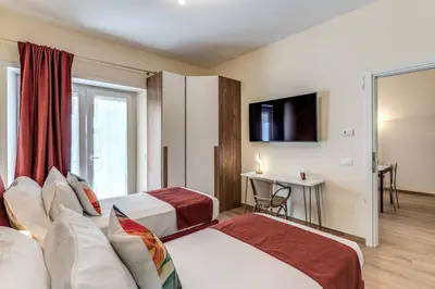 a hotel room with two beds and a television at Trilocale indipendente vicino Metro per Colosseo - Domus in Rome in Rome