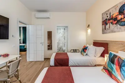 a hotel room with two beds and a desk at Trilocale indipendente vicino Metro per Colosseo - Domus in Rome in Rome