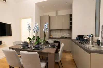 a kitchen and dining room with a table and chairs at A Casa Tua Vatican Suite in Rome