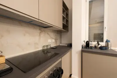 a kitchen with white cabinets and a counter top at A Casa Tua Vatican Suite in Rome