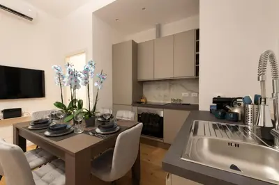 a kitchen with a table and a kitchen with a sink at A Casa Tua Vatican Suite in Rome