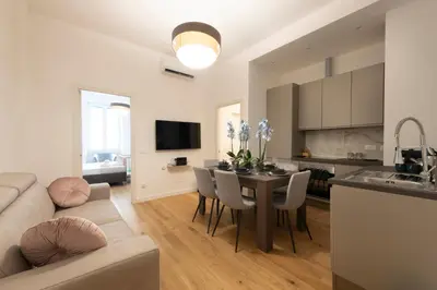 a kitchen and living room with a table and a couch at A Casa Tua Vatican Suite in Rome