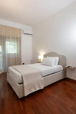 a bedroom with a large white bed and a window at Residenza in Vaticano Roma in Rome