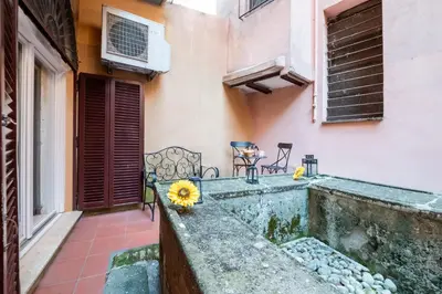 a balcony with two chairs and a table with flowers at Number Five Apartment in Trastevere in Rome