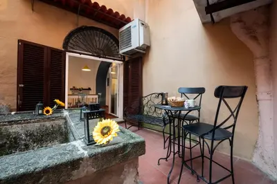 a patio with two chairs and a table with sunflowers at Number Five Apartment in Trastevere in Rome