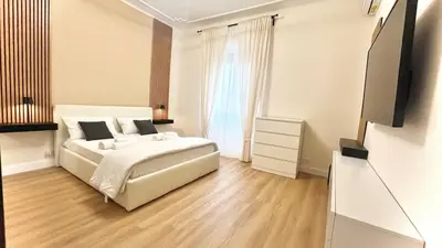 a white bedroom with a bed and a television at LH Vatican Museum Wi-Fi AC Flat Premium Comfort in Rome
