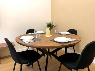 a wooden table with chairs and plates and glasses on it at LH Vatican Museum Wi-Fi AC Flat Premium Comfort in Rome