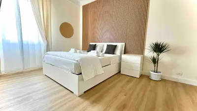 a bedroom with a white bed and a potted plant at LH Vatican Museum Wi-Fi AC Flat Premium Comfort in Rome