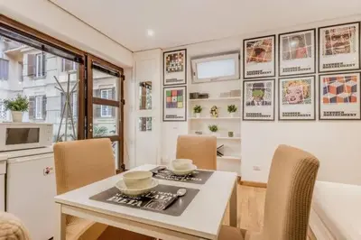 a dining room with a table and chairs and a kitchen at Green Loft di Trastevere in Rome