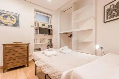 a white bedroom with two beds and a dresser at Green Loft di Trastevere in Rome