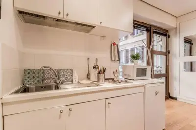 a white kitchen with a sink and a microwave at Green Loft di Trastevere in Rome